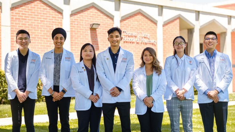 Group of pharmacy students in white coats.