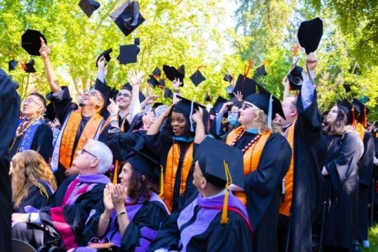 Graduates throw their caps in the air.