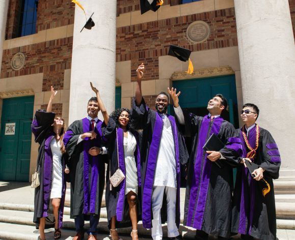 a group of grads throwing their caps in the air